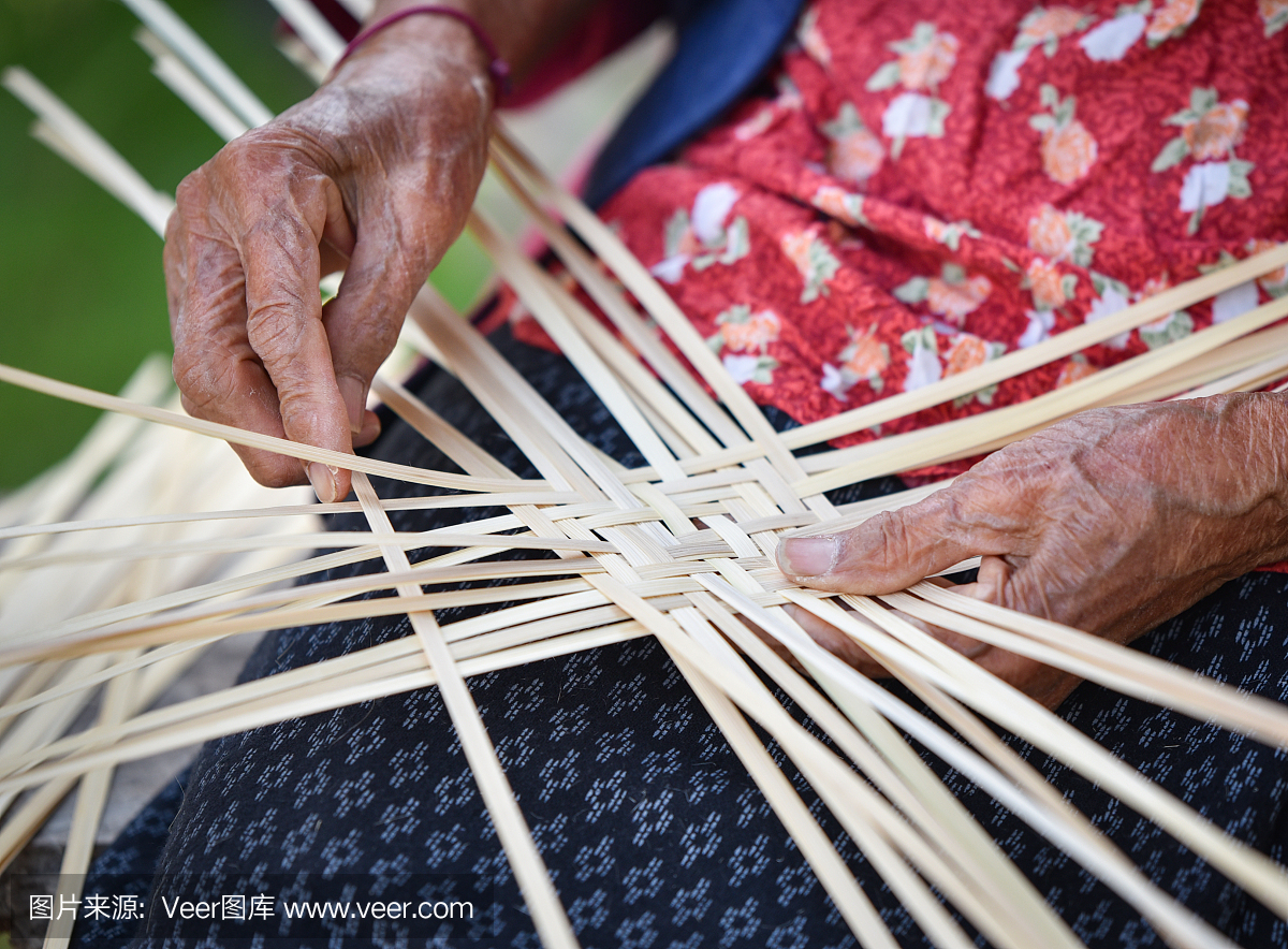 老年妇女手工制作工艺品编织竹制篮子的自然产品在泰国亚洲